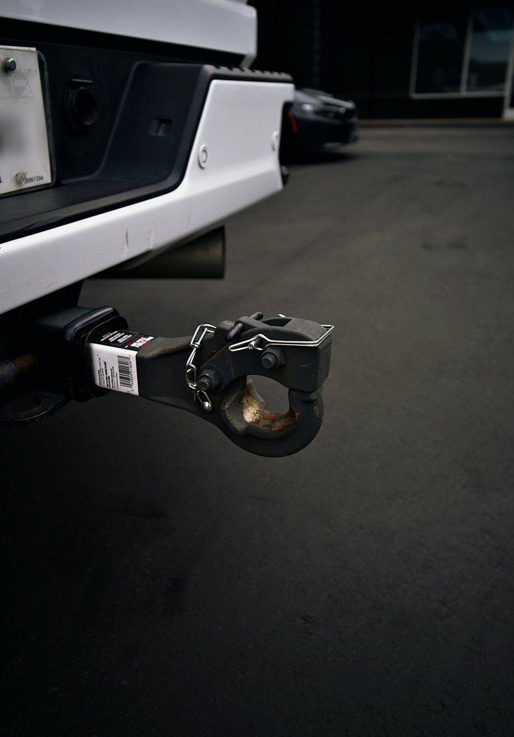 Rusted tow hitch attached to the bumper of a truck.